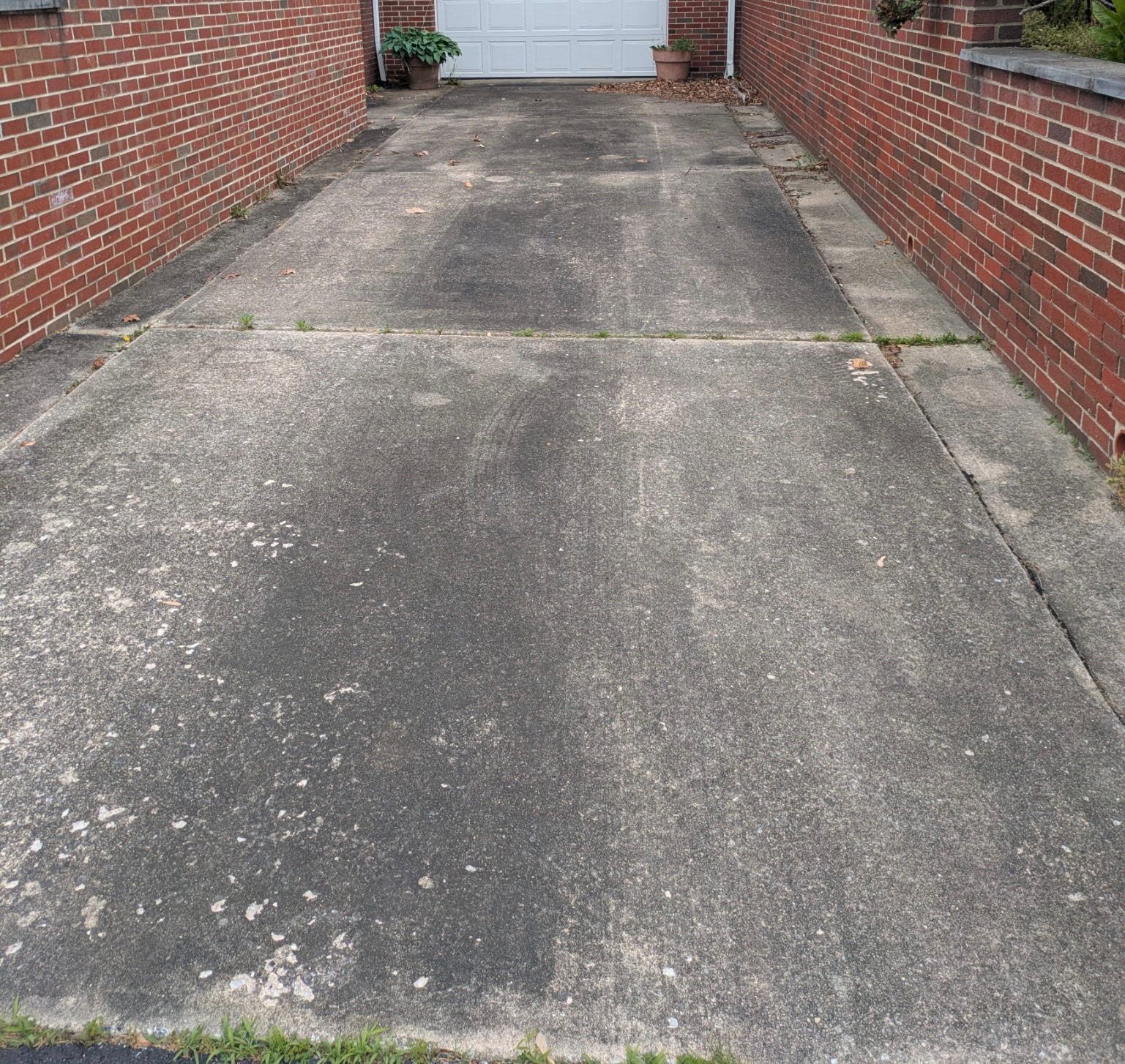 Untreated concrete driveway before pressure washing